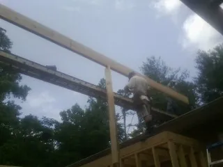 Carpenter setting a ridge beam over a new addition frame — Ice Dam Removal by Roofing Brothers in Hurricane Mills