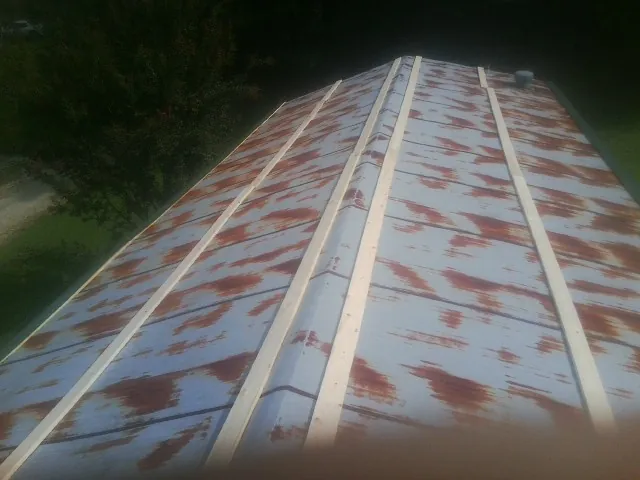 Rusted metal roof panels with new wood purlins before replacement — Storm Damage Roof Repair in Hurricane Mills by Roofing Brothers