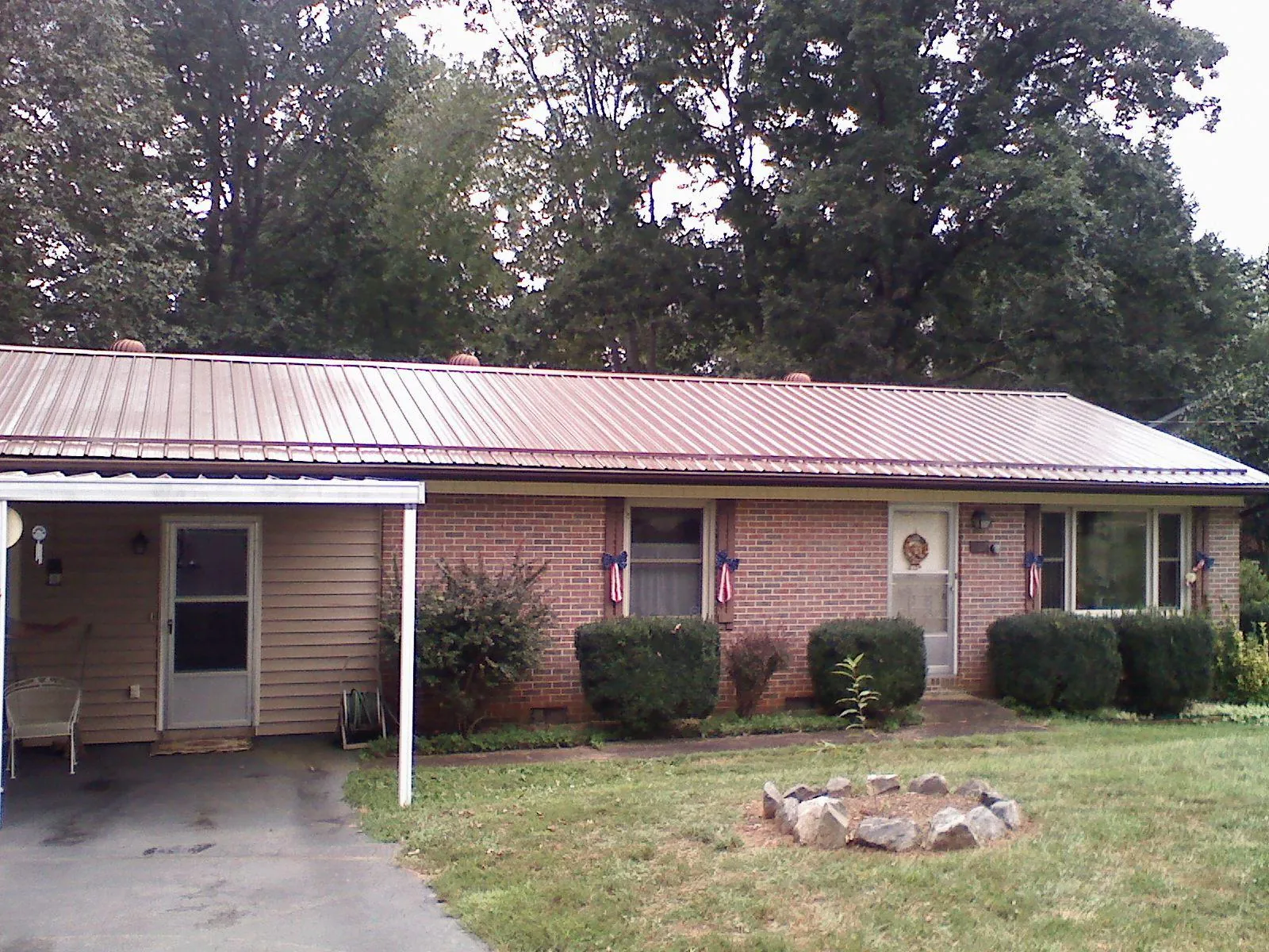 Bronze metal roof and carport on a brick ranch home — Roof Repair work by our crew in Hurricane Mills