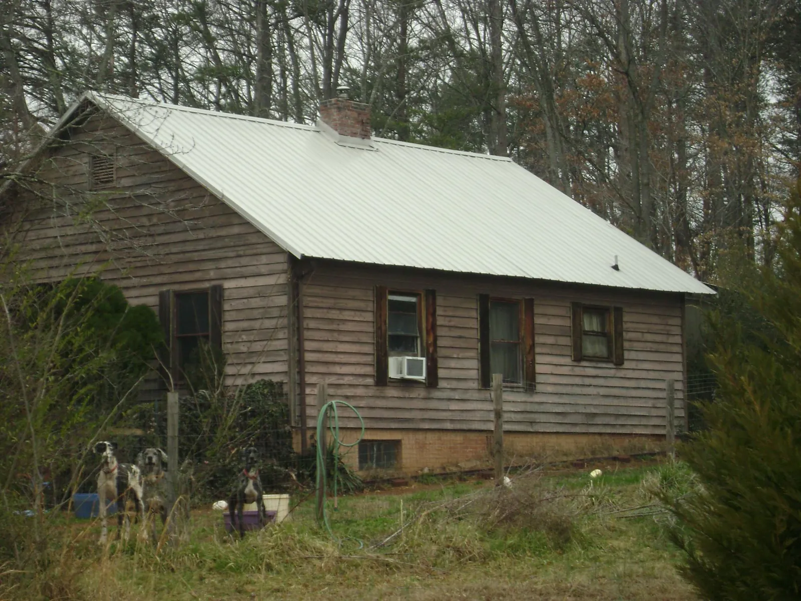 White metal roof on an old wood sided farmhouse, from a Metal Roof Installation job in Hurricane Mills